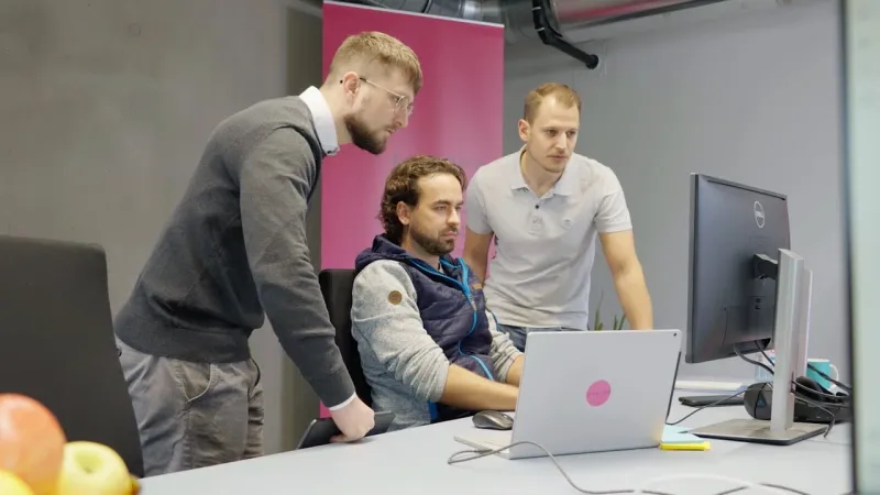 Three Guid.New developers working together at a screen